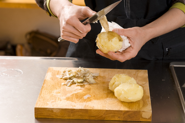 ジャガイモは1個づつ濡らしたペーパータオルで包んでからラップで包み、電子レンジで5分程度加熱し、取り出して皮を剥き、食べやすい大きさに切る。玉ねぎは薄切りにする。
