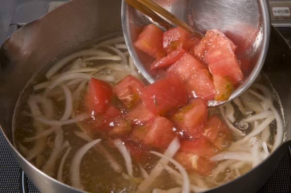 鍋にAと千切りにした玉ねぎを入れる。沸騰したら酒、塩、ざく切りにしたトマトを入れる。