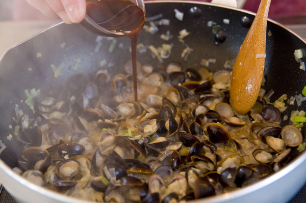 シジミの殻が開いたらしょうゆとオイスターソースを加え混ぜる。残りのゴマ油を回し入れてザッと混ぜたら、器に盛り万能ネギを散らす。