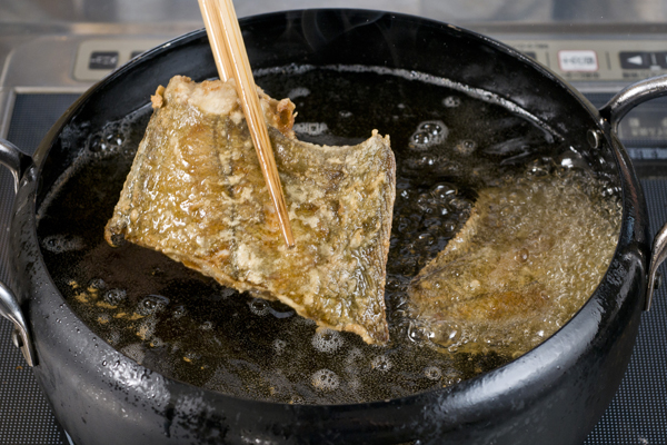 赤カレイは半身にし、塩をしてから小麦粉を付けて揚げる。大根をおろし、ネギの青い部分を刻んでおく。