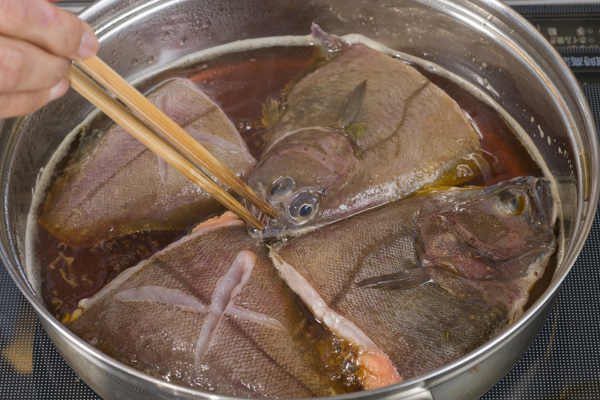 鍋に水と酒を入れ、沸騰したら砂糖、しょうゆを加えて煮立て、カレイの表を上にして並べ入れる。