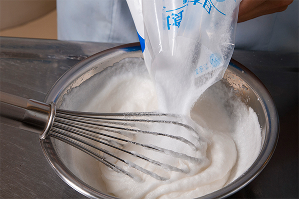 卵白を泡立て、何度かに分けて粗塩を加えながら混ぜていく。（塩釜つくり）