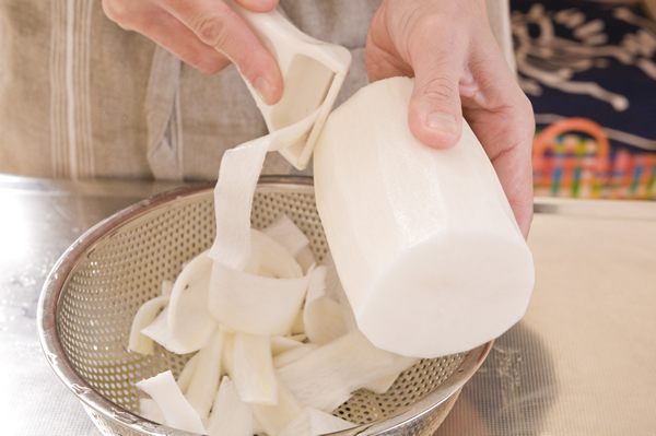 大根は皮を剥いて、縦にピーラーでリボン状に全量削ぎ、食べやすい長さに切る。しょうがは皮ごと千切りにする。