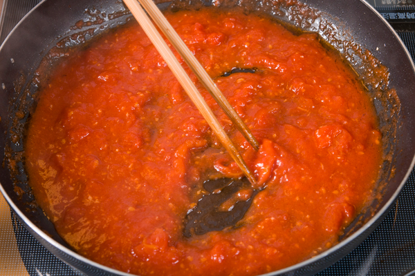 金目鯛を取り出した①のフライパンにトマト缶を入れ、加熱しながら水気を飛ばす。