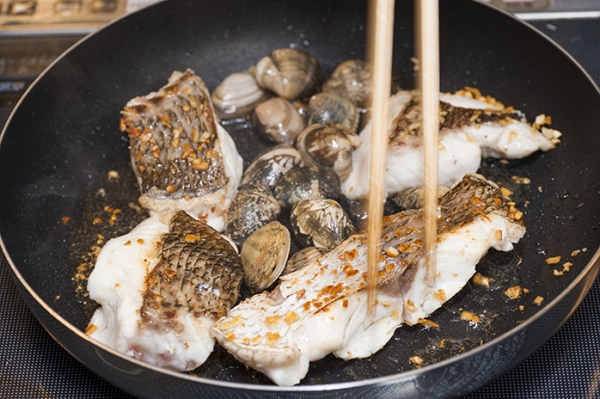 フライパンにオリーブオイルを熱し、にんにくを弱火で香りが立つように炒める。①の真鯛と砂抜きしてよく洗ったあさりを炒める。