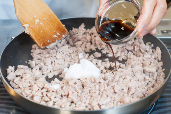 調味料を入れて、煮詰まるまで煮る。 小口切りにした青ねぎと白ゴマをまぜて出来上がり。 ゆでて小口切りにしたいんげんと、炒り卵とともにご飯の上に盛り付ける。