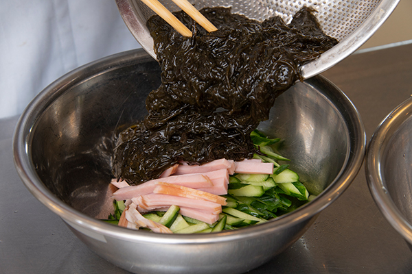 千切りしたきゅうり、ハムと混ぜる。砂糖、酢、しょうゆ、中華だし、ゴマ油をいれ、よく混ぜる。