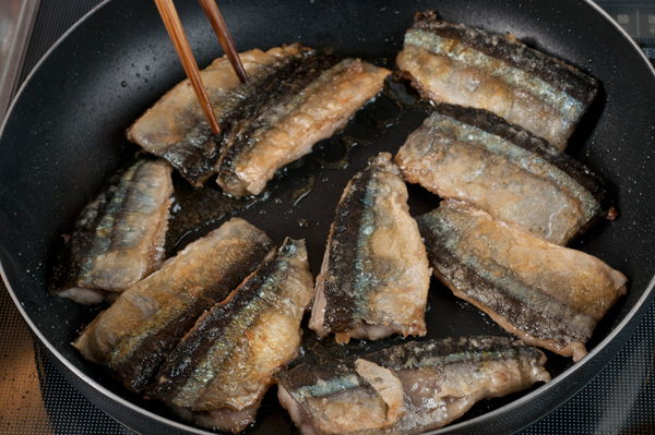 サンマの両面に片栗粉をつけて、ごま油を熱したフライパンでよく焼き、一旦皿に取り出す。