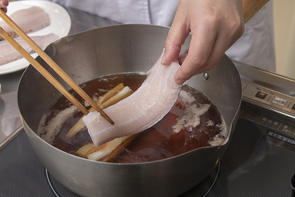 鍋に水と調理酒、みりん、しょうゆ、砂糖を入れてひと煮たちさせ、タチウオ、ししとうを加える。落し蓋をして10～15分ほど煮る。