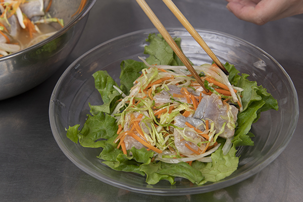 2⃣の野菜を皿に盛り、トビウオとつけ汁を盛り付け、最後にレモンを飾る。