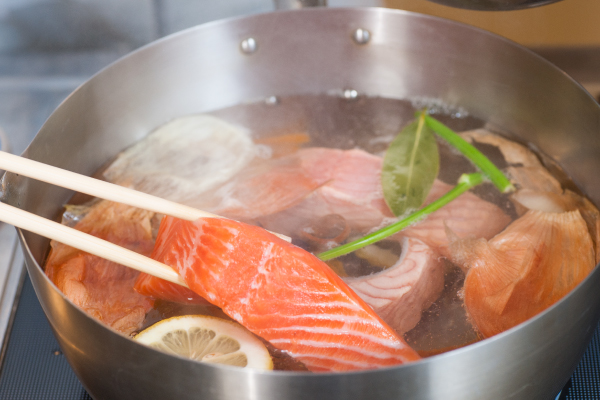 水、白ワイン、輪切りにしたレモン、野菜くず、ローリエを鍋に入れ、沸騰させる。ふくいサーモンを入れて再沸騰させ、弱火で5分ゆでる。サーモンを取り出して冷ます。