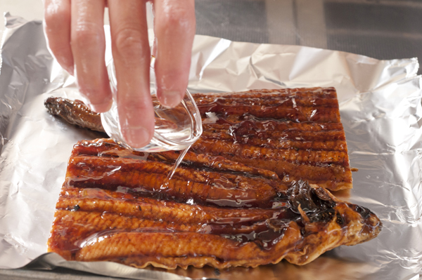 うなぎかば焼きに酒をまんべんなく塗り、グリルかオーブントースターで香ばしい香りが立つまで焼き、幅1㎝程度に切る。